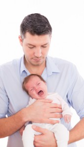Vater hält schreiendes Baby in der Hand
