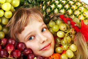 Kind mit Trauben,Kirschen und Ananas