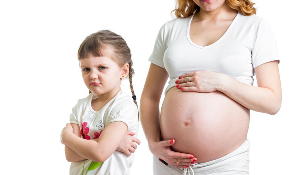 Ein beleidigtes Kind steht vor einer schwangeren Frau
