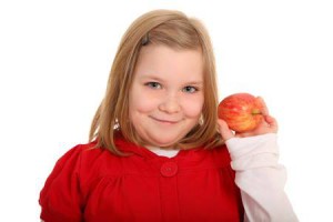 Ein Mädchen hält einen Apfel